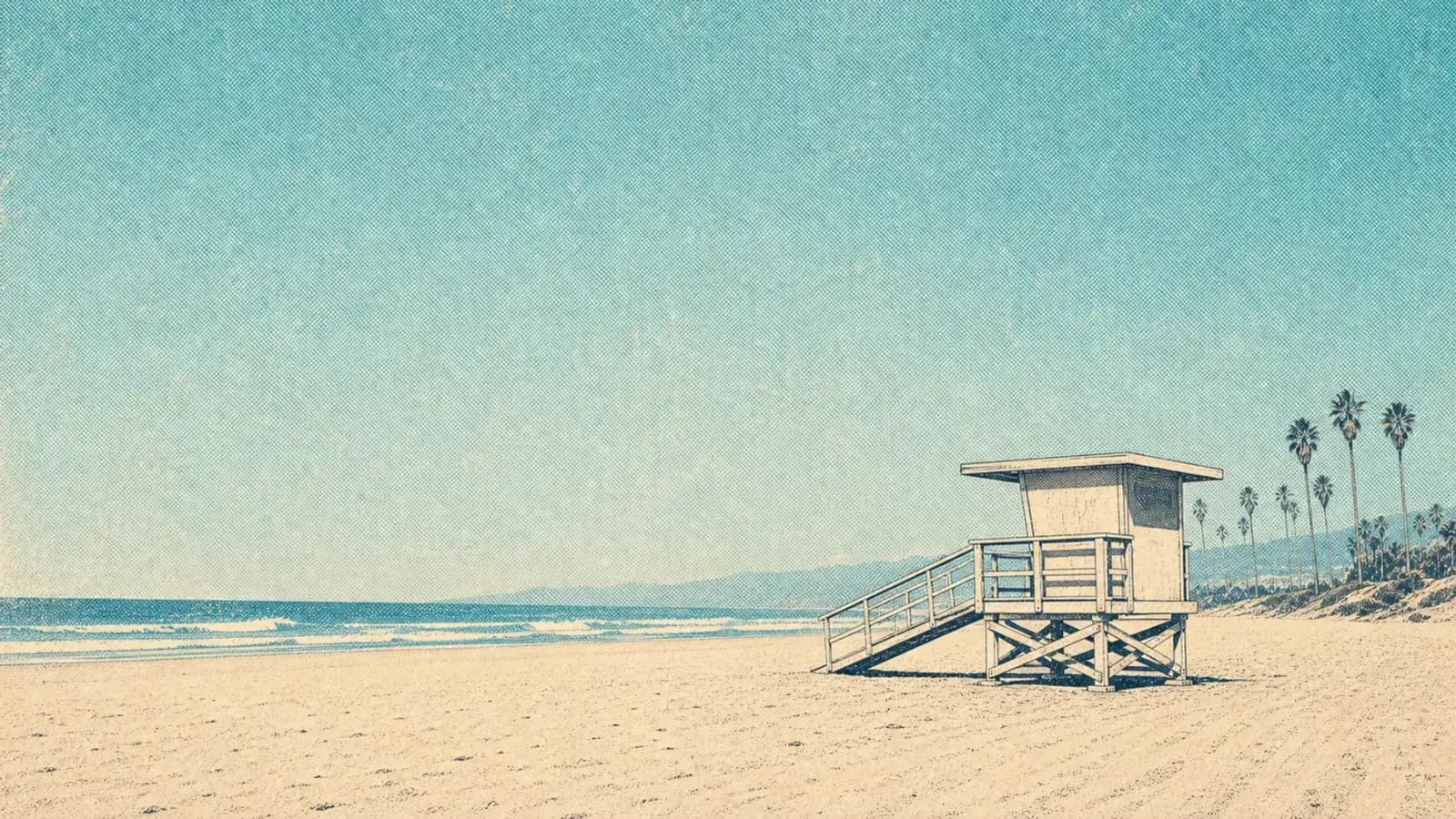 A cream lifeguard tower on a wide, bright California beach